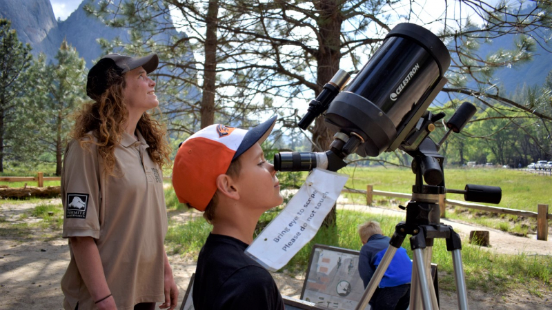 One of the 2018 Yosemite Climber Stewards helps young visitors connect with the vertical world at the seasonal Ask a Climber station. Photo: Yosemite Conservancy/Ryan Kelly